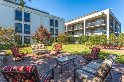 a group of chairs and tables in front of a building at Clarion Pointe Huntsville Research Park in Huntsville