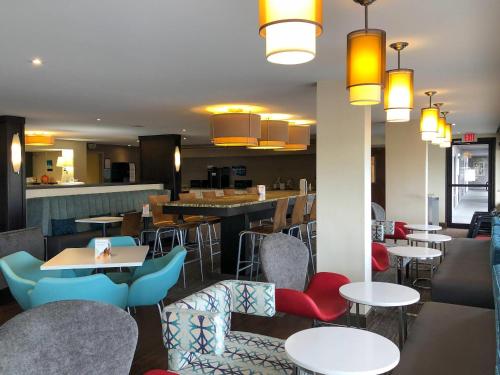a restaurant with tables and chairs and a bar at Clarion Pointe Huntsville Research Park in Huntsville