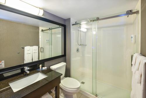 a bathroom with a shower and a toilet and a sink at Comfort Inn in Charlottetown