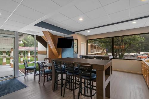 une salle à manger avec un bar avec des chaises et des fenêtres dans l'établissement Quality Inn Westfield - Springfield, à Westfield