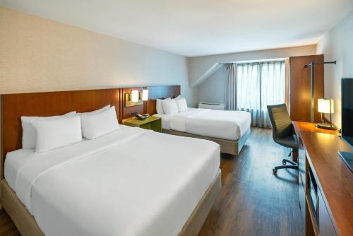 a hotel room with two beds and a desk at Comfort Inn in Charlottetown