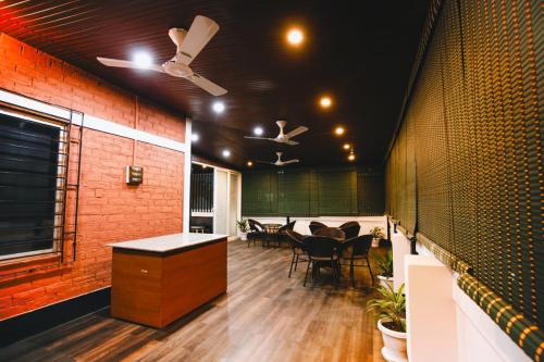 a room with tables and chairs and a brick wall at Nivasa Homestay - Khanapara Guwahati in Guwahati