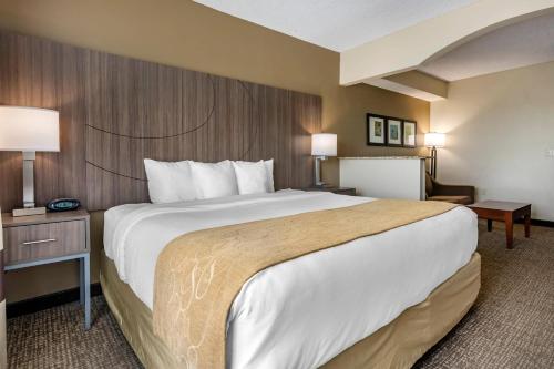 a hotel room with a large bed and a desk at Comfort Suites Sawgrass in Tamarac