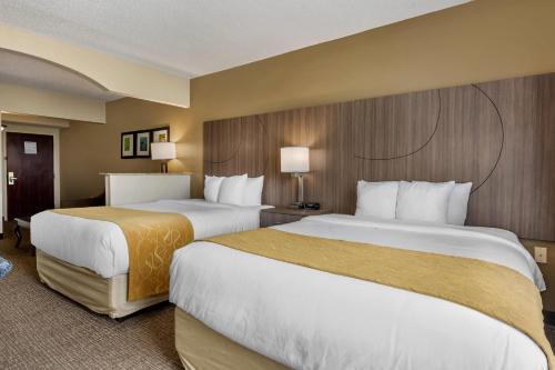 a hotel room with two beds and two lamps at Comfort Suites Sawgrass in Tamarac