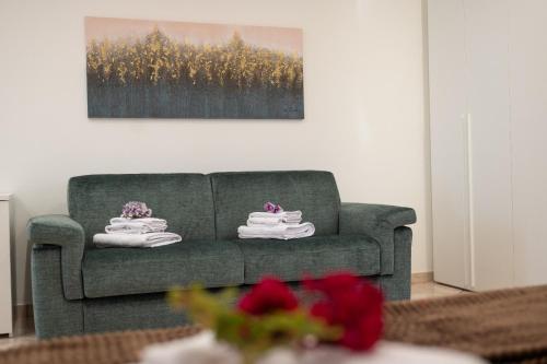 a living room with a green couch and a painting at From Flori in Terrasini