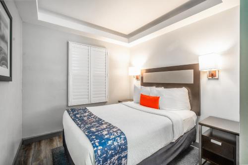 a hotel room with a bed with a orange pillow at Inn at 50 Long Beach Convention Center in Long Beach