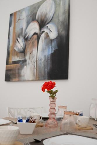 a table with a vase with a red flower in it at From Flori in Terrasini