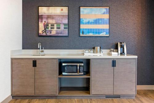 a kitchen with a sink and a microwave at Cambria Hotel Downtown Asheville in Asheville