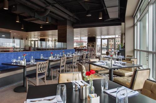 a dining room with tables and chairs and windows at Cambria Hotel Downtown Asheville in Asheville