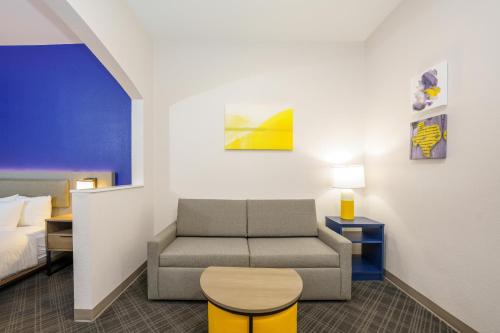 a living room with a couch and a bed at Comfort Suites University Drive in College Station