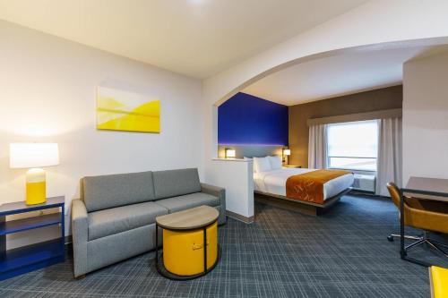 a hotel room with a bed and a couch at Comfort Suites University Drive in College Station
