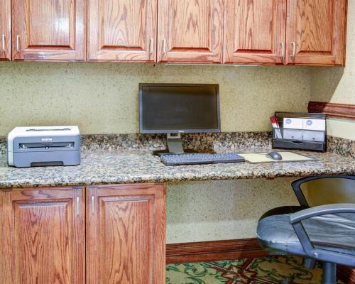 a kitchen with a desk with a computer and a keyboard at Comfort Suites University Drive in College Station