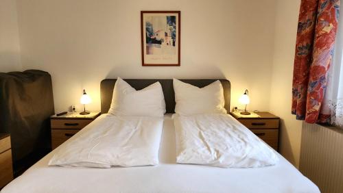 a bedroom with a bed with two pillows and two lamps at Zimmervermietung Stocker in Waidhofen an der Ybbs