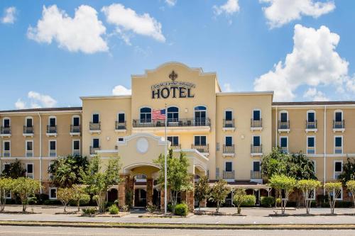 a hotel with an american flag in front of it at Evangeline Downs Hotel, an Ascend Collection Hotel in Opelousas