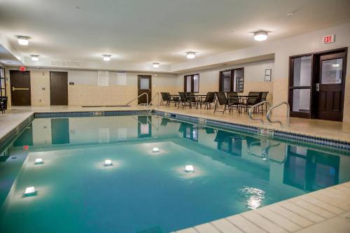 a large swimming pool in a hotel with tables and chairs at Evangeline Downs Hotel, an Ascend Collection Hotel in Opelousas