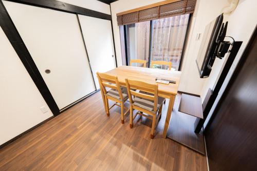 a dining room with a table and chairs and a television at JPRESERVE Hachijoguchi in Kyoto