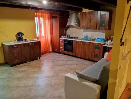 a kitchen with wooden cabinets and a couch in it at Antico Borgo in Spinetoli
