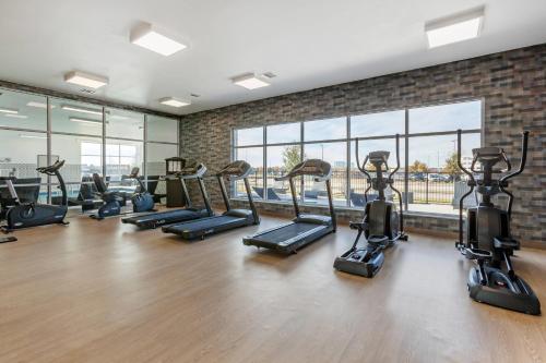 a gym with a bunch of tread machines in a room at Cambria Hotel Plano - Richardson Garland in Richardson