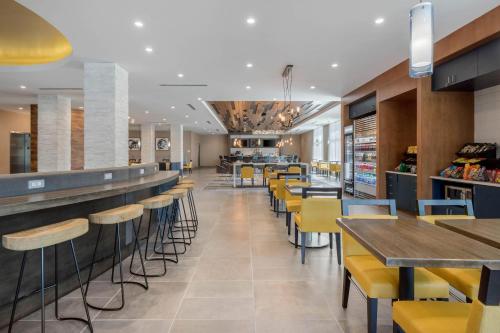a restaurant with yellow chairs and a bar at Cambria Hotel Mount Pleasant - Charleston in Charleston