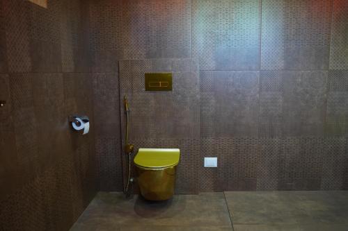 a bathroom with a yellow toilet in a room at Room Marakkech Mazha at Samara Farms Calicut in Kozhikode