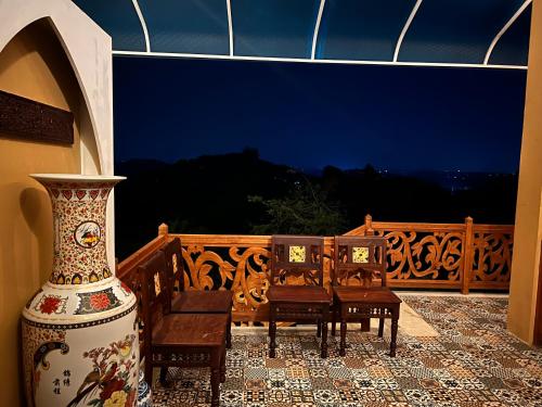 a balcony with chairs and a vase on a patio at Room Marakkech Mazha at Samara Farms Calicut in Kozhikode