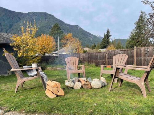 two chairs and a table in a yard with rocks at Cozy Private Suite with HOT TUB fire pit and AC! in Hope