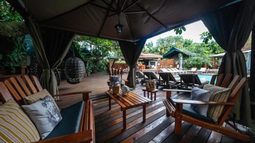 a wooden deck with chairs and an umbrella at Luxury Tented Village @ Urban Glamping in St Lucia