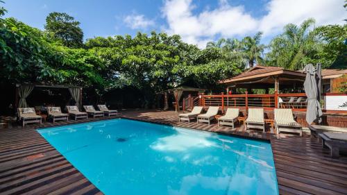 a swimming pool with lounge chairs and a pavilion at Luxury Tented Village @ Urban Glamping in St Lucia