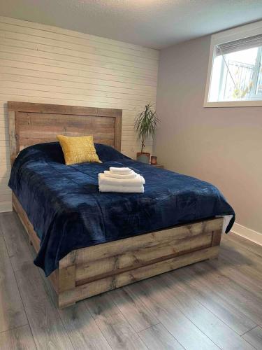 a bedroom with a large bed with a blue blanket at Cozy Private Suite with HOT TUB fire pit and AC! in Hope