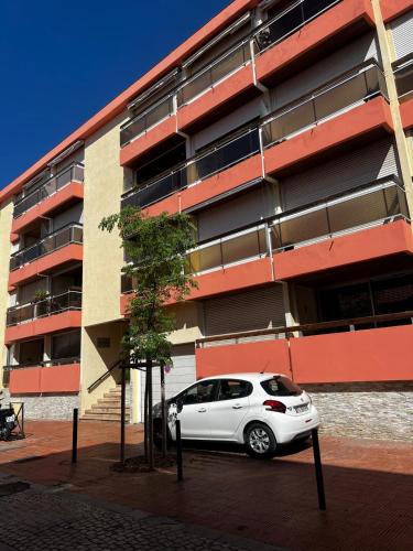 une voiture blanche garée devant un immeuble dans l'établissement Astrella, à Bandol