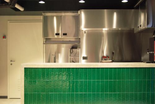 cocina con encimera de azulejos verdes en CONCEPT PERA Hotel, en Estambul