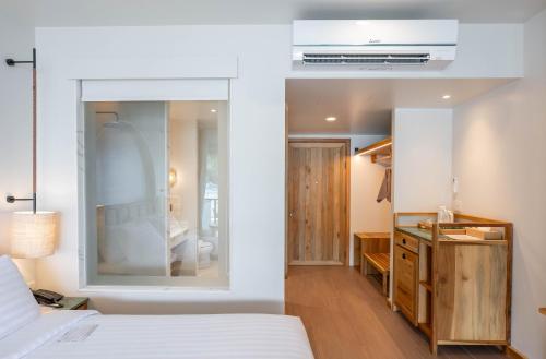 a bedroom with a bed and a dresser at Phi Phi at Pier in Phi Phi Don