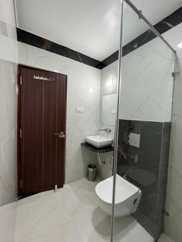 a bathroom with a toilet and a sink and a shower at Hotel Kavaka in Sambalpur