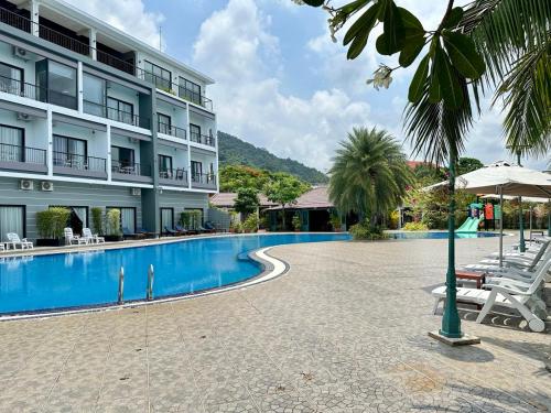 a hotel with a swimming pool in front of a building at KEP BAY HOTEL & RESORT in Kep