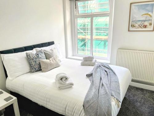 a bedroom with a bed with towels on it at Top Floor Apt Promenade Sea Views Sleeps 6 Shore Vibes in Morecambe
