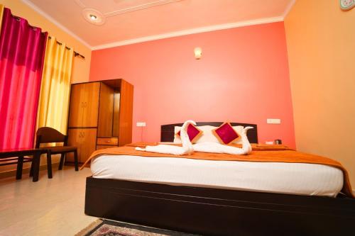 a bedroom with a large bed with orange walls at Shivalik River Retreat in Almora