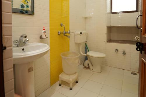 a bathroom with a toilet and a sink at Shivalik River Retreat in Almora