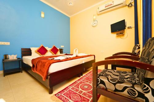 a bedroom with a bed and a chair and a tv at Shivalik River Retreat in Almora