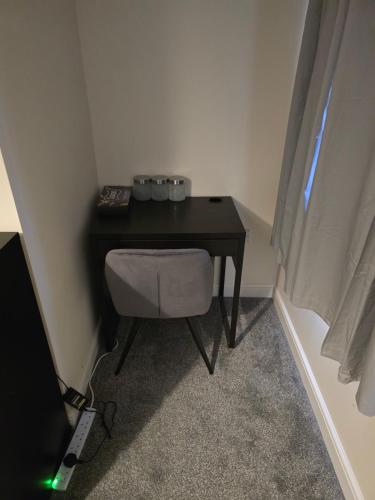 a small black table in a room with a television at Quiet Ensuite Room in Rotherham in Rawmarsh