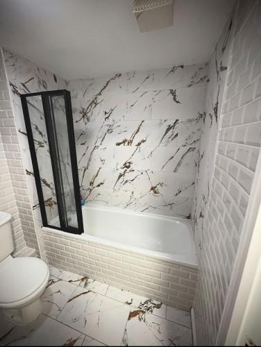a bathroom with a tub and a toilet and a sink at Perfect for construction workers and building contractors in Manchester