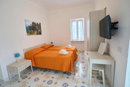 a small bedroom with a bed and a television at Casa Nannina in Anacapri