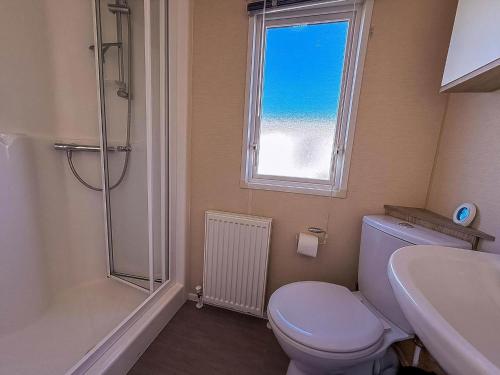 a bathroom with a toilet and a sink and a window at Modern 6 Berth Caravan With Free Wifi Nearby Pakefield Beach Ref 68028Cr in Lowestoft