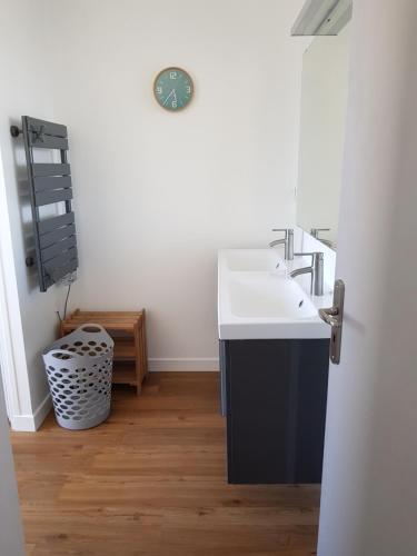 une salle de bain avec un lavabo et un miroir dans l'établissement Maison quartier calme, à 600m de la plage, jardin clos exposé sud, à Le Relecq-Kerhuon