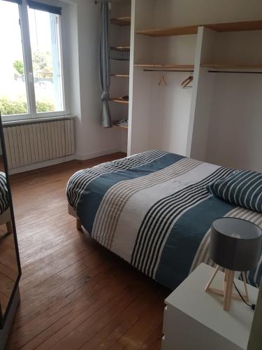 une chambre avec un lit, un bureau et une fenêtre dans l'établissement Maison quartier calme, à 600m de la plage, jardin clos exposé sud, à Le Relecq-Kerhuon