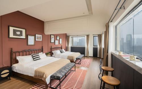 a bedroom with two beds and a large window at 重庆大野江景民宿 in Chongqing