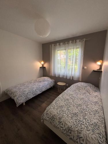une chambre avec deux lits et une fenêtre dans l'établissement Gîte La Bienvenue, à Saint-Martin-Plage