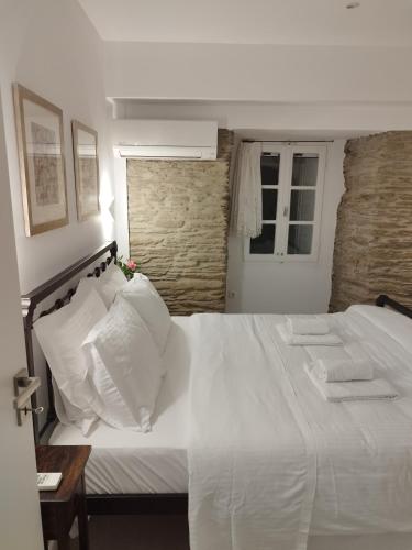 a bedroom with a large white bed with white pillows at Korina's Suites in Andros
