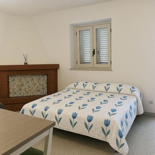 a bedroom with a bed and a table and a window at Casa Vacanza Aria di Mare in Policoro