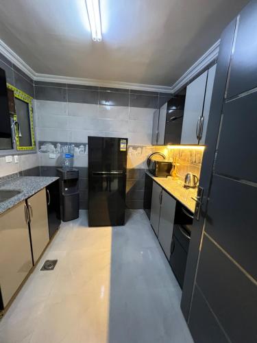 a small kitchen with black cabinets and counters at المهندسين ميدان لبنان2 in Cairo