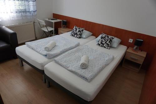 two beds in a small room with two at Május 1 Vendégház - Torony in Torony